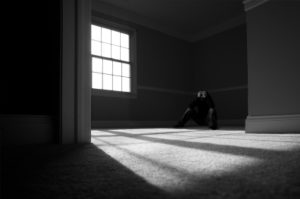 A person alone in a room in a corner
