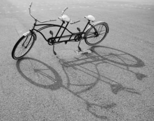 A black and white image of a tandem bicycle