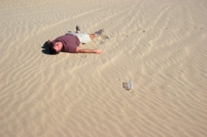 A man lays dying in the desert