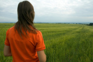 woman looking out onto an expanse of a field