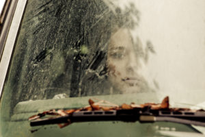 lonely woman staring out through a car windshield