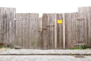 A dilapidated fence with differing boards