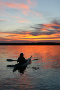 woman in a canoe at sunset