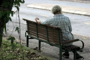 an older gentleman sitting alone on a bench