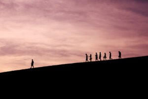 A man walking far in front of a crowd