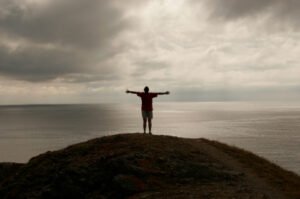 standing by the sea with arms open