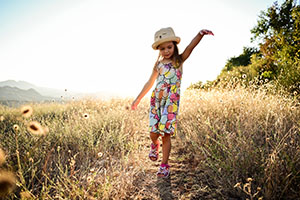 A young girl skipping through a field