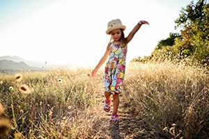 A young girl skipping through a field