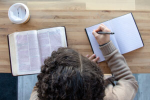 A woman reading the Bible and taking notes