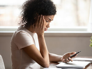 a woman looking up information on her phone and computer