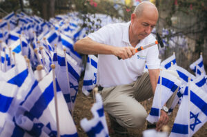 A man placing Israel flags in the ground
