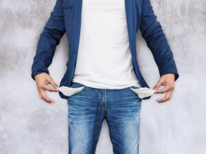 A man in blue jeans revealing his empty pockets