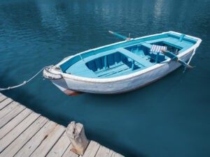 An old wooden fishing boat is moored to the harbor