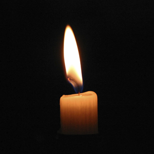 A candle burning brightly in the darkness
